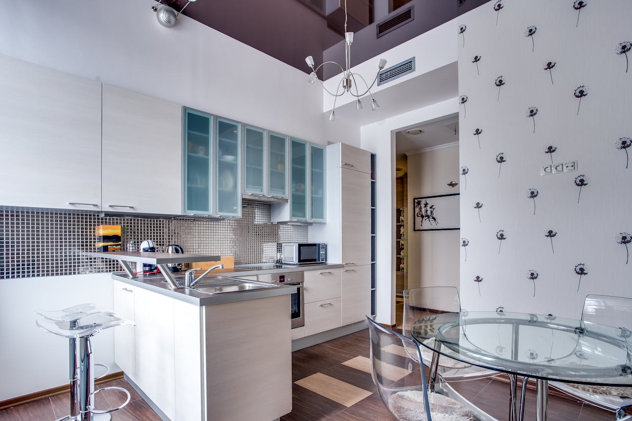 A kitchen with a white table and chairs and a black and white wallpaper